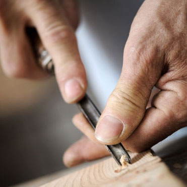 un artigiano che incide il legno